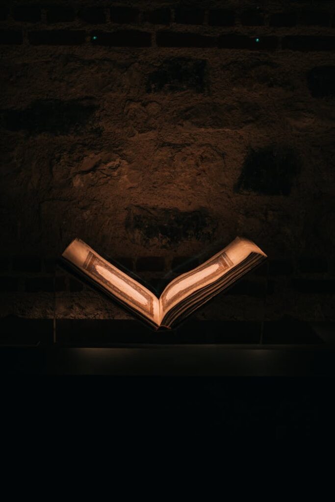 Mastering the First Impression: Your intriguing post title goes here Dramatic photo of an illuminated open book against a rustic stone wall, exuding a vintage and sacred aura.