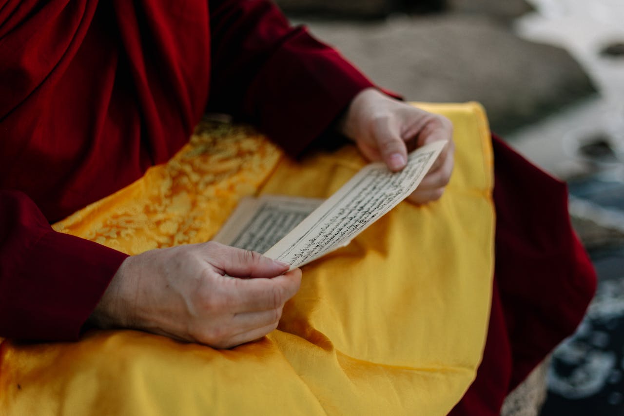 Kodu Close-up of a monk reading sacred text, highlighting ritual significance and serenity.
